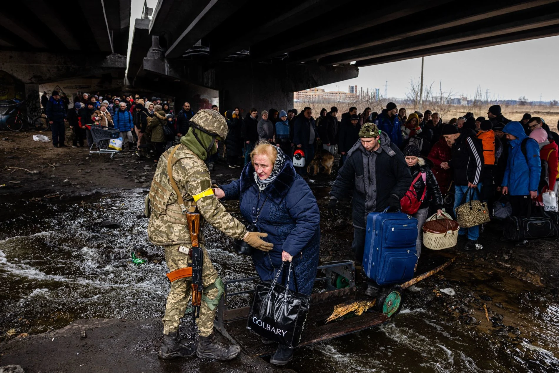 Ukrainian serviceman helps evacuees (AFP/ Getty Images)