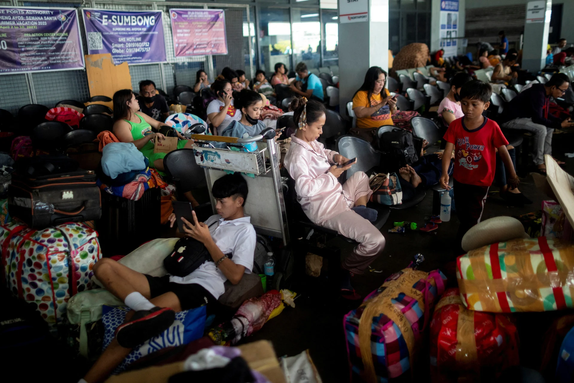 REUTERS: Stranded passengers at the Manila North Port take shelter at the terminal amid cancelled trips due to Typhoon Doksuri, in Manila, Philippines, July 25, 2023. REUTERS/Eloisa Lopez