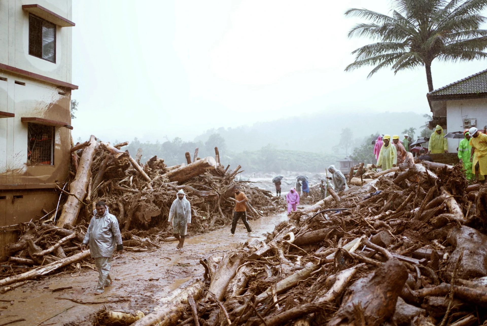 Reuters: People walk past debris at a landslide site after multiple landslides in the hills in Wayanad, in the southern state of Kerala, India, July 30, 2024. REUTERS/CK Thanseer