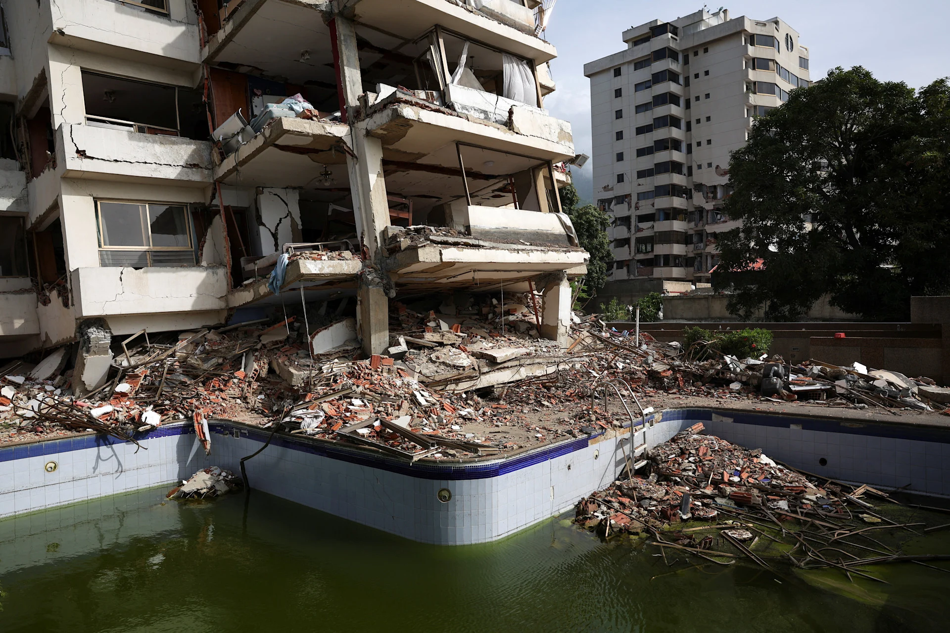 Reuters: Debris lies scattered in and around a swimming pool next to a damaged building in the aftermath of the June 24 earthquakes, in La Guaira, Venezuela, July 4, 2026. REUTERS/Pablo Sanhueza