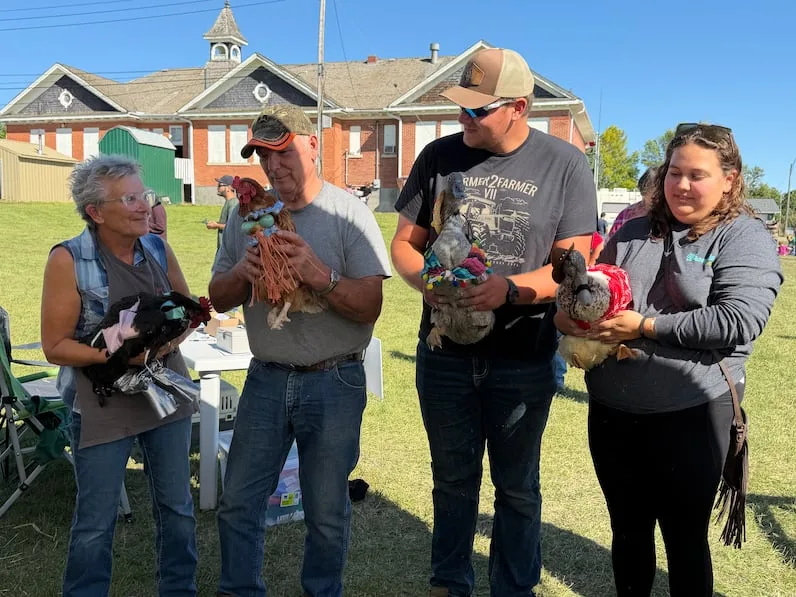 CBC Kathy Russell, far left, holds one of her two entries in the contest, while Harleigh Carlson, far right, hangs on to one of her two cowboy-costumed ducks. (Shawn Mullin/CBC)