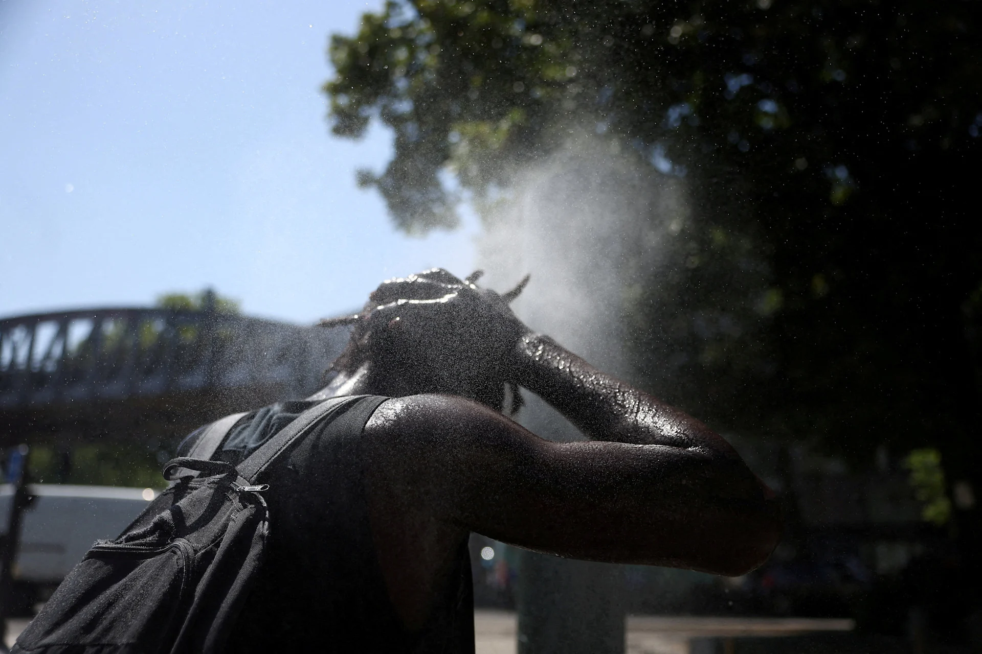 Reuters: FILE PHOTO: A person cools off at a water mister on a street in Paris as temperatures rise during a heatwave affecting a large part of France, June 22, 2026. REUTERS/Alice Sacco/File Photo
