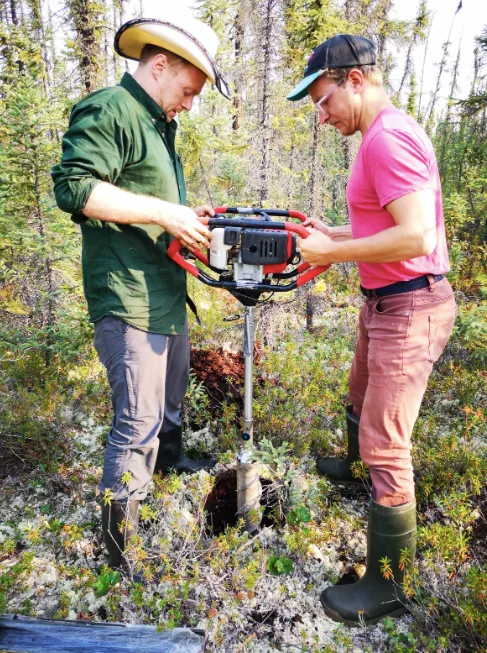 Researchers collect a permafrost soil core in a peatland near Wrigley, N.W.T. (David Olefeldt)