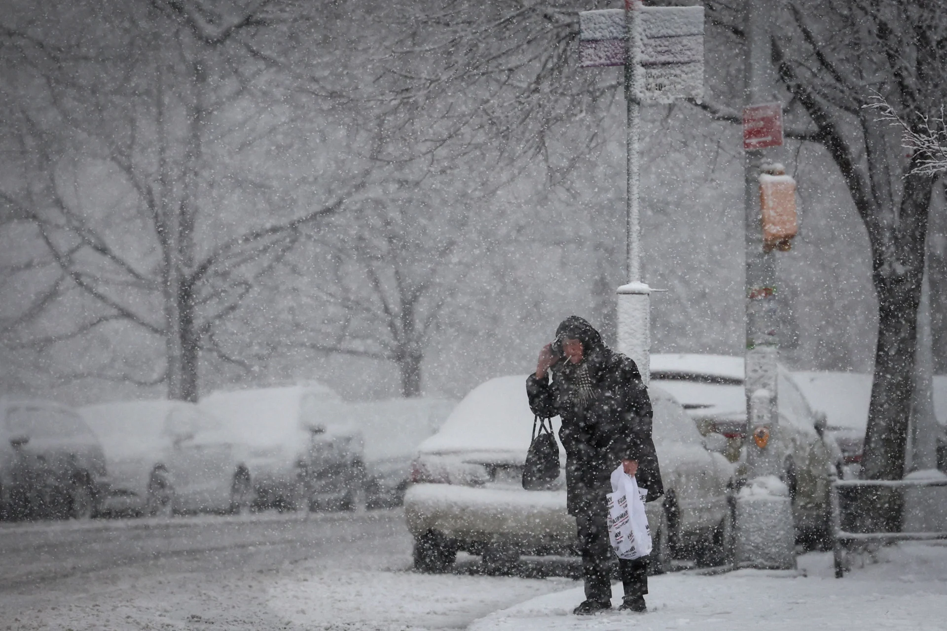 REUTERS: A woman waits at a bus stop during heavy snowfall during winter weather in Manhattan in New York City, U.S., February 13, 2024. REUTERS/Mike Segar