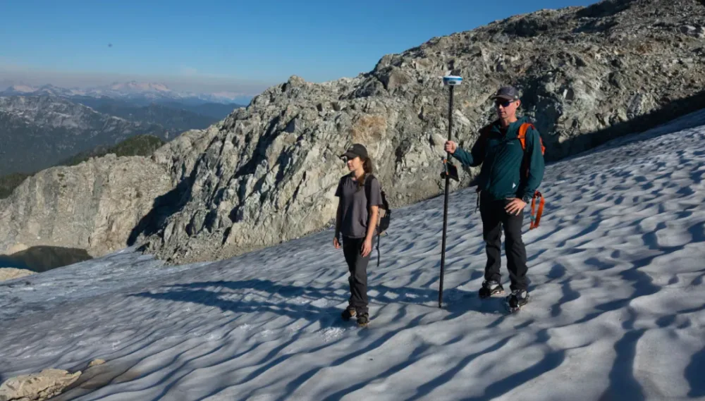 Georgia Dixon, left, and Peter Marshall, a field hydrologist, stand near the Coquitlam Glacier on Thursday, Oct. 13, 2022. (Maggie MacPherson/CBC)