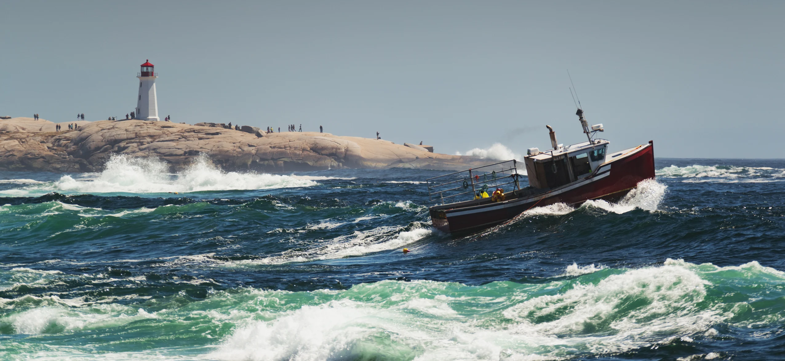 Lobster boat hauls traps in heavy surf near Peggy's Cove Lighthouse. Credit: shaunl. E+. Getty Images