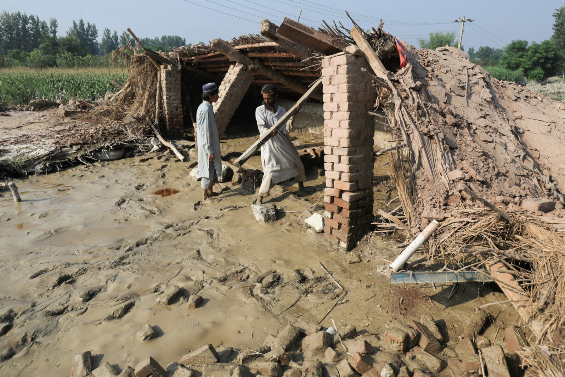Men remove wooden planks from their damaged house, following rains and floods during the monsoon season in Nowshera, Pakistan August 30, 2022. REUTERS/Fayaz Aziz