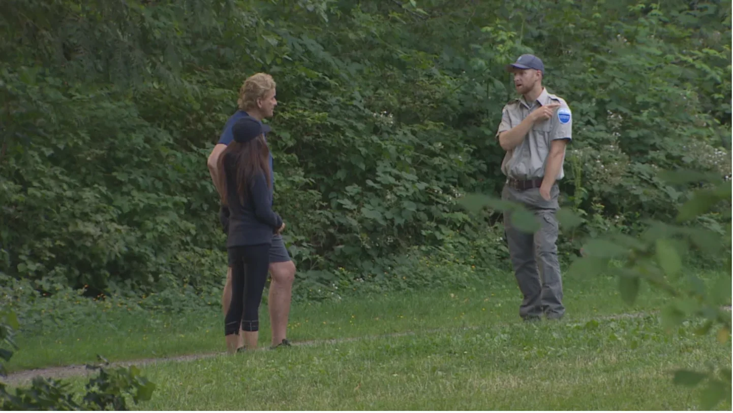 CBC: Two people speak to a park ranger near Rice Lake in North Vancouver on Friday, after a child was bitten by a bear. (Harman/CBC)