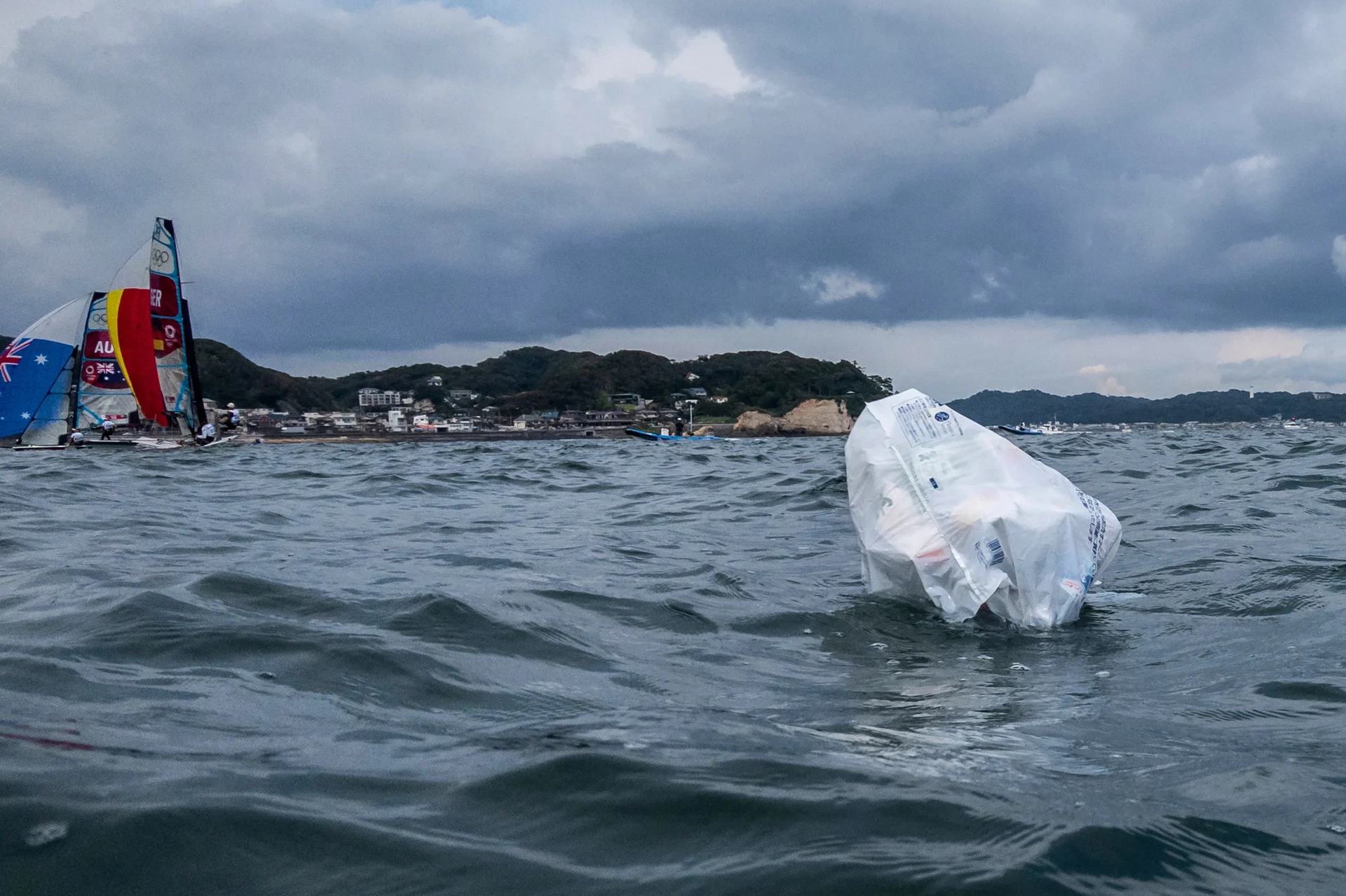 Reuters: FILE PHOTO: Tokyo 2020 Olympics. A plastic bag containing trash floats on the water as competitors warm up for their race. REUTERS/Carlos Barria