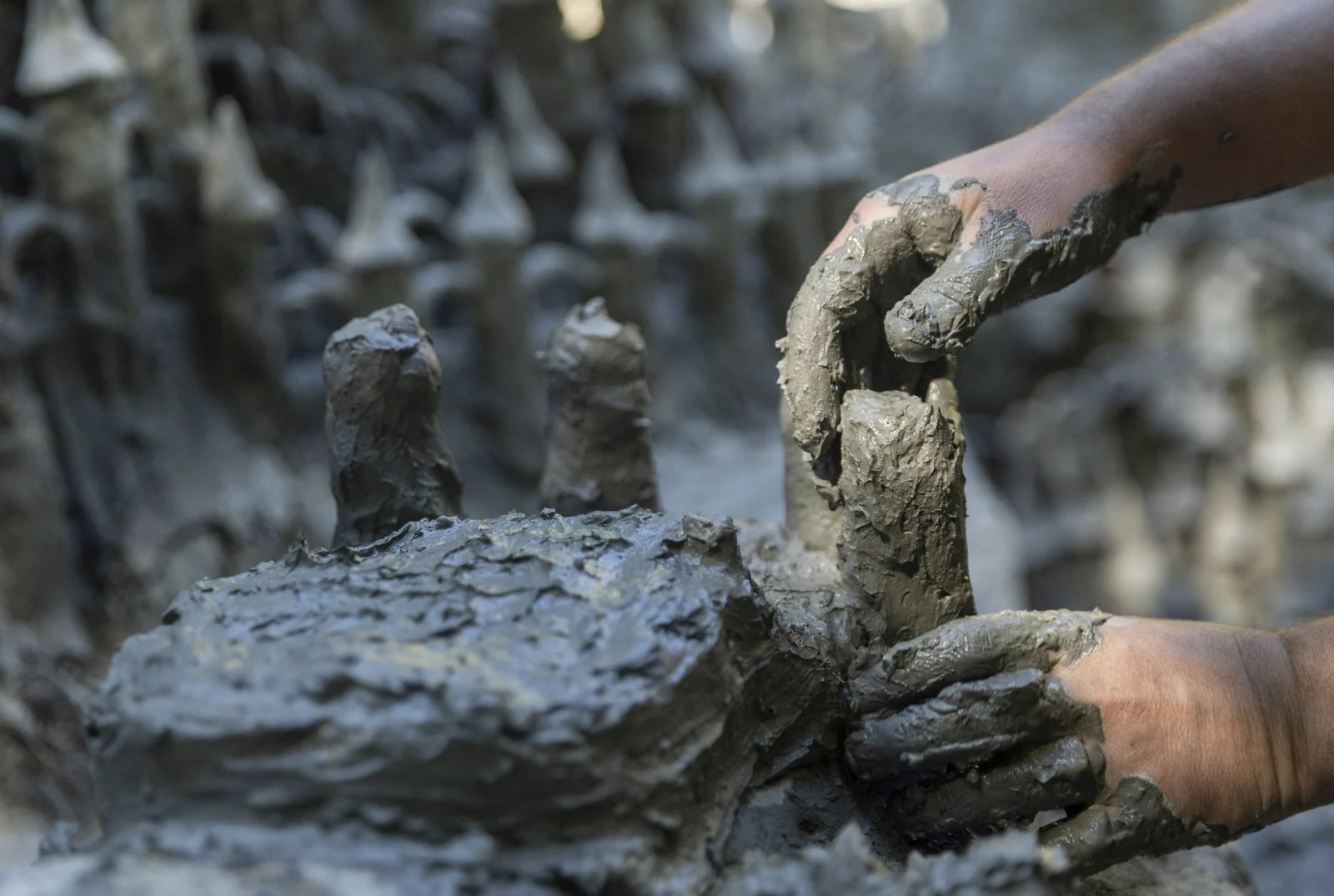 Land art artist Francois Monthoux works on his "Monthoux castle" made out of clay retrieved from the dried bed of Le Toleure river due to ongoing drought, in Saubraz, Switzerland, August 12, 2022. REUTERS/Denis Balibouse