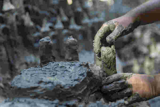 Land art kunstenaar François Monthaux werkt aan zijn werk "Monthox-kasteel" Gemaakt van klei teruggewonnen uit de droge bodem van de rivier Le Toleure als gevolg van aanhoudende droogte, in Saubraz, Zwitserland, 12 augustus 2022. REUTERS/Denis Balibouse