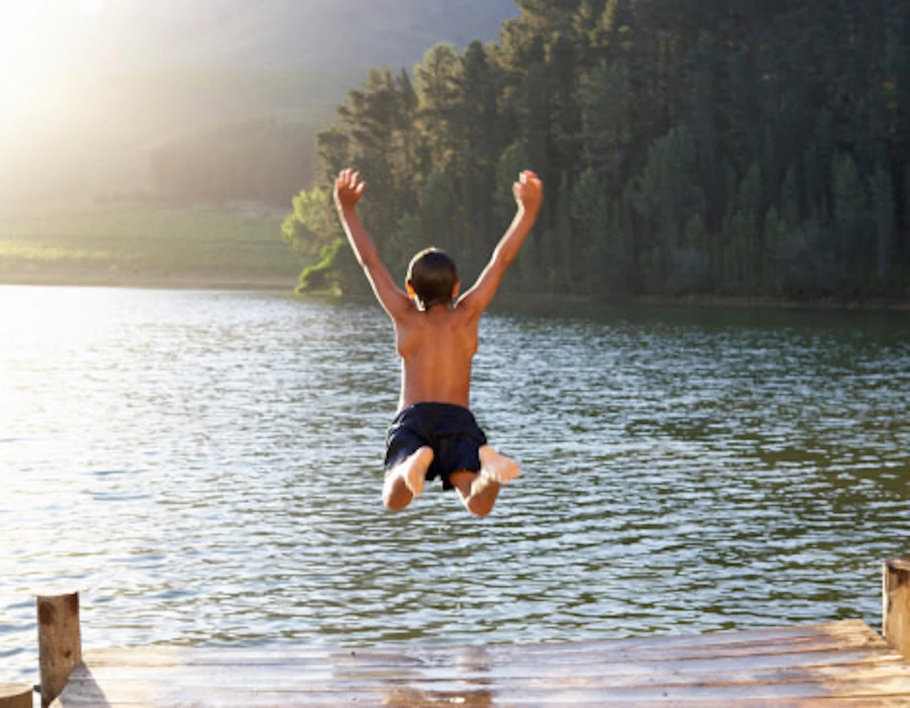 getty boy jumping into lake summer (1)