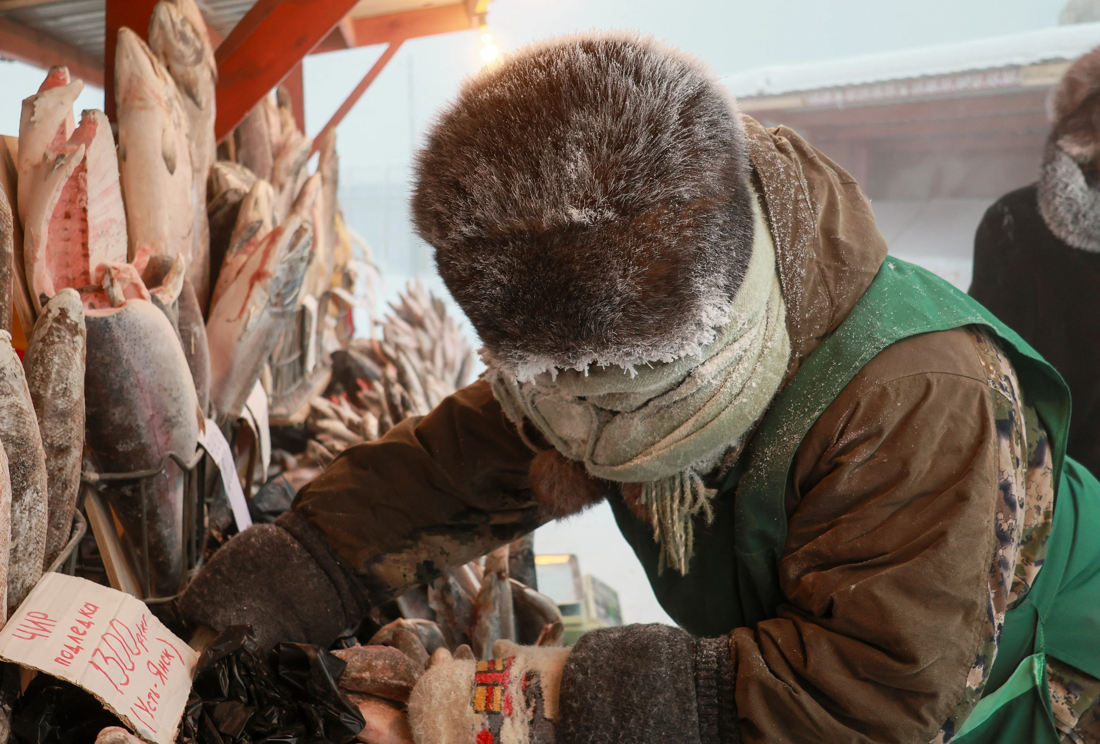 Reuters: A vendor serves customers at an open-air market on a frosty day in Yakutsk, Russia, December 5, 2023. Temperatures in parts of the Sakha Republic, also known as Yakutia and located in the northeastern part of Siberia, went below minus 50 degrees Celsius (minus 58 degrees Fahrenheit) on December 5. REUTERS/Roman Kutukov