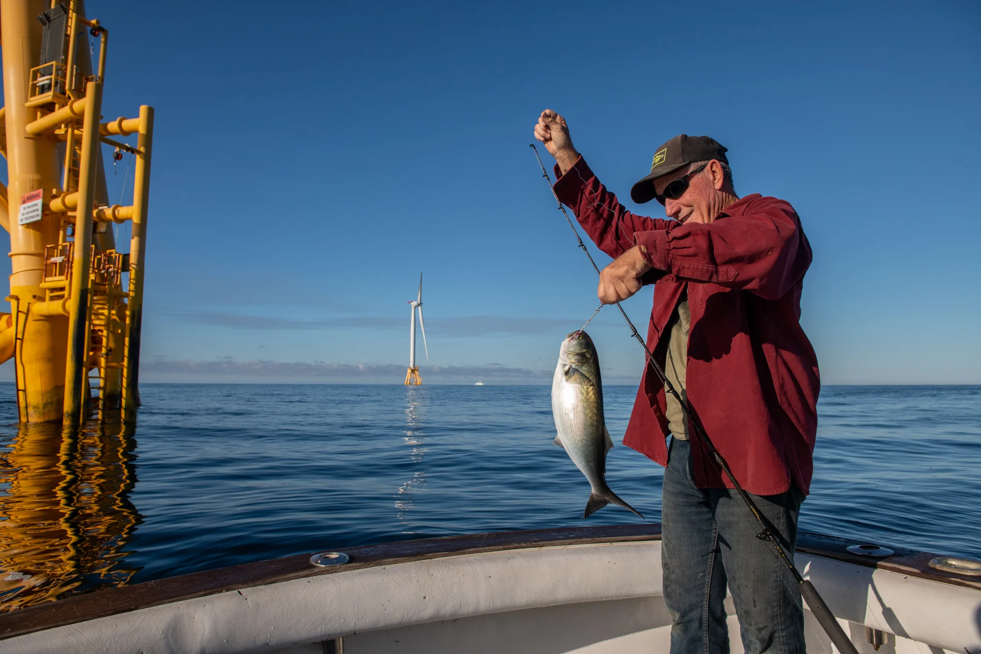 Captain Steve Miller is with a blue fish he caught near the Block Island Wind Farm. Rhode Island, U.S. Miller, a full-time resident of Block Island, joined the United States Coast Guard at age seventeen, fished commercially in his twenties, and held a 100-Ton Master Captain's License from the Coast Guard for several years. (Neil Ever Osborne)