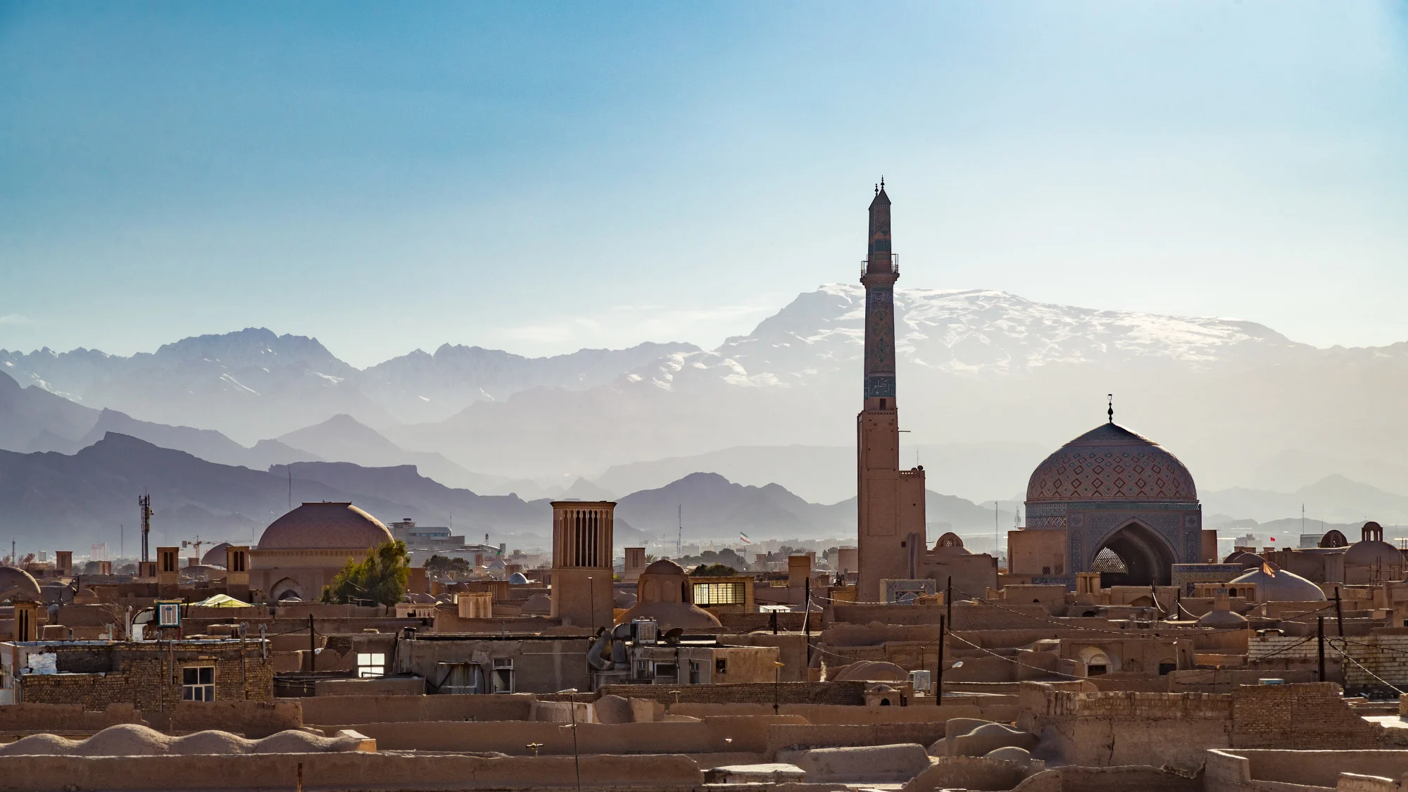 Jameh Mosque and snowcapped mountains in Yazd, Iran. Credit: Jean-Philippe Tournut. Moment. Getty Images