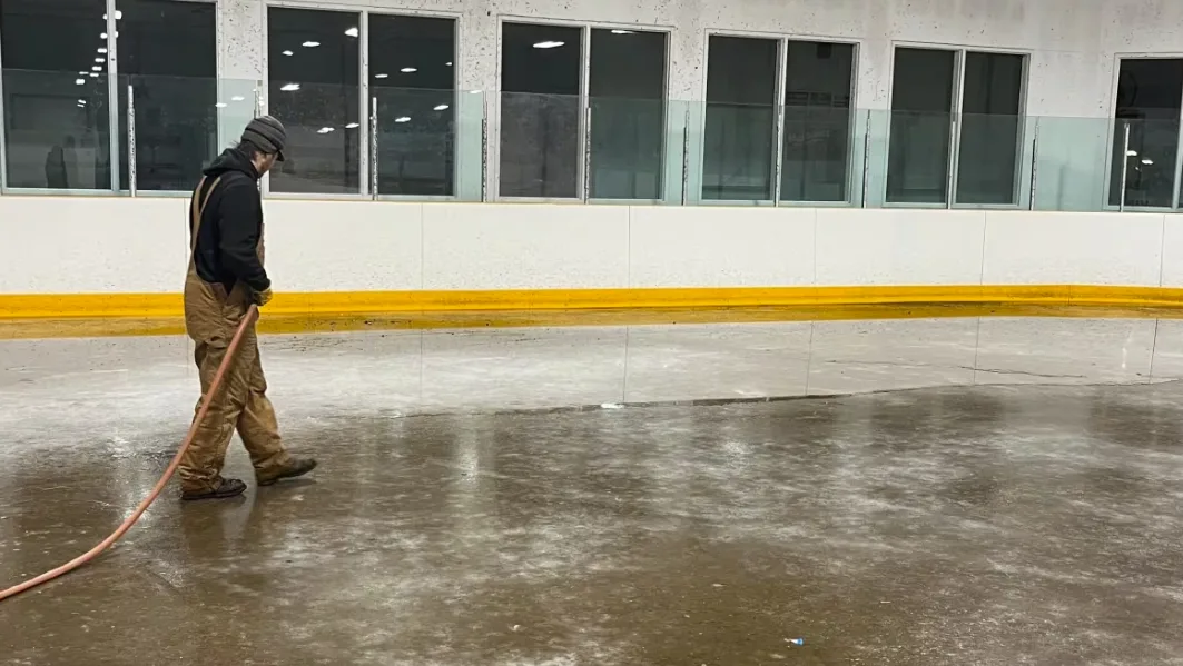 CBC: Rink workers say they have had to work odd hours and use creative solutions to set and maintain the ice in Radisson. Pictured here, one rink volunteer floods the ice in late November. (Submitted by Dustin Bezugly)