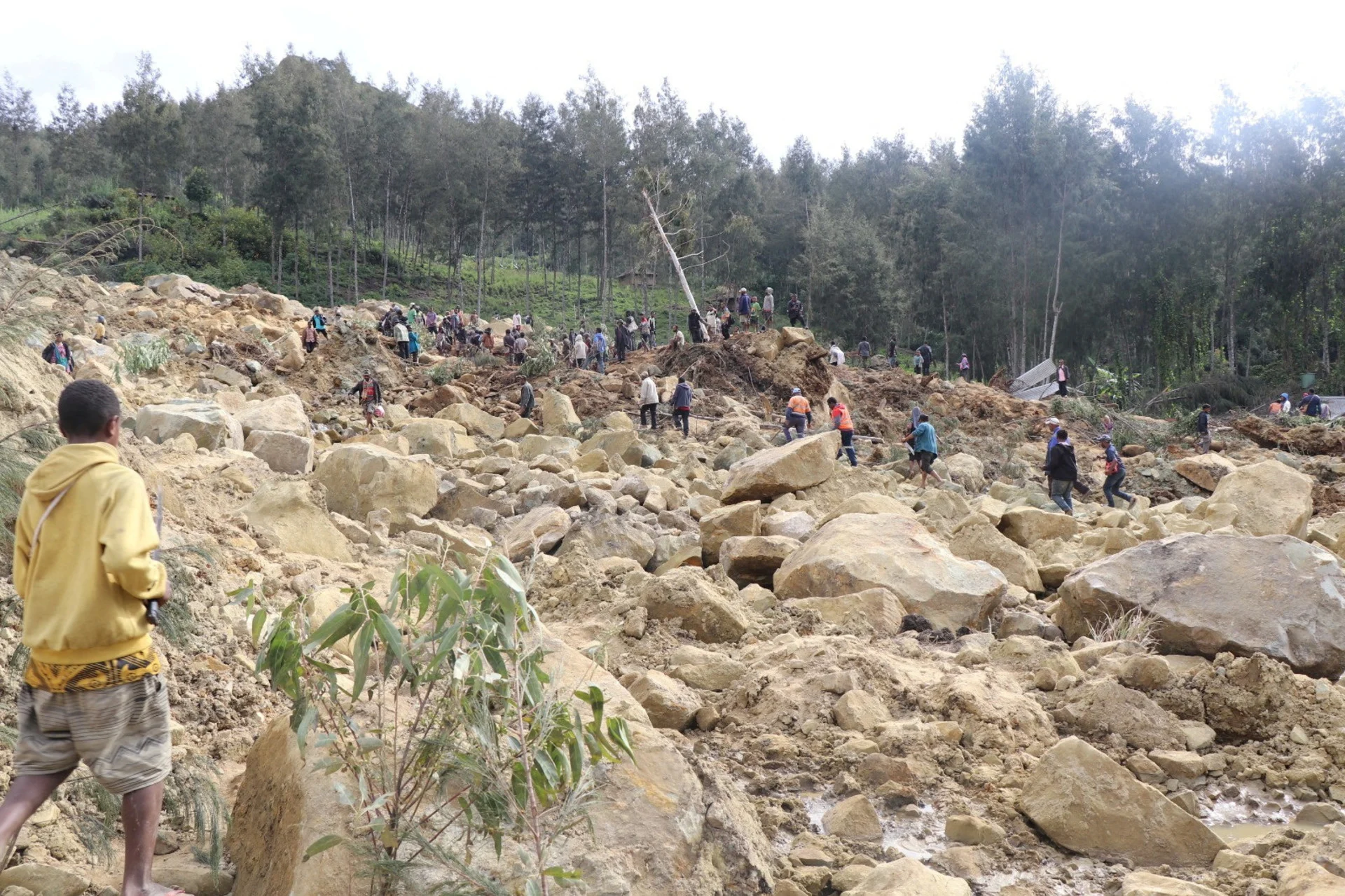 Reuters: Relief workers and people walk at a site damaged in the aftermath of a landslide in Enga Province, Papua New Guinea, May 26, 2024, in this handout image obtained by Reuters. New Porgera Limited/Handout via REUTERS