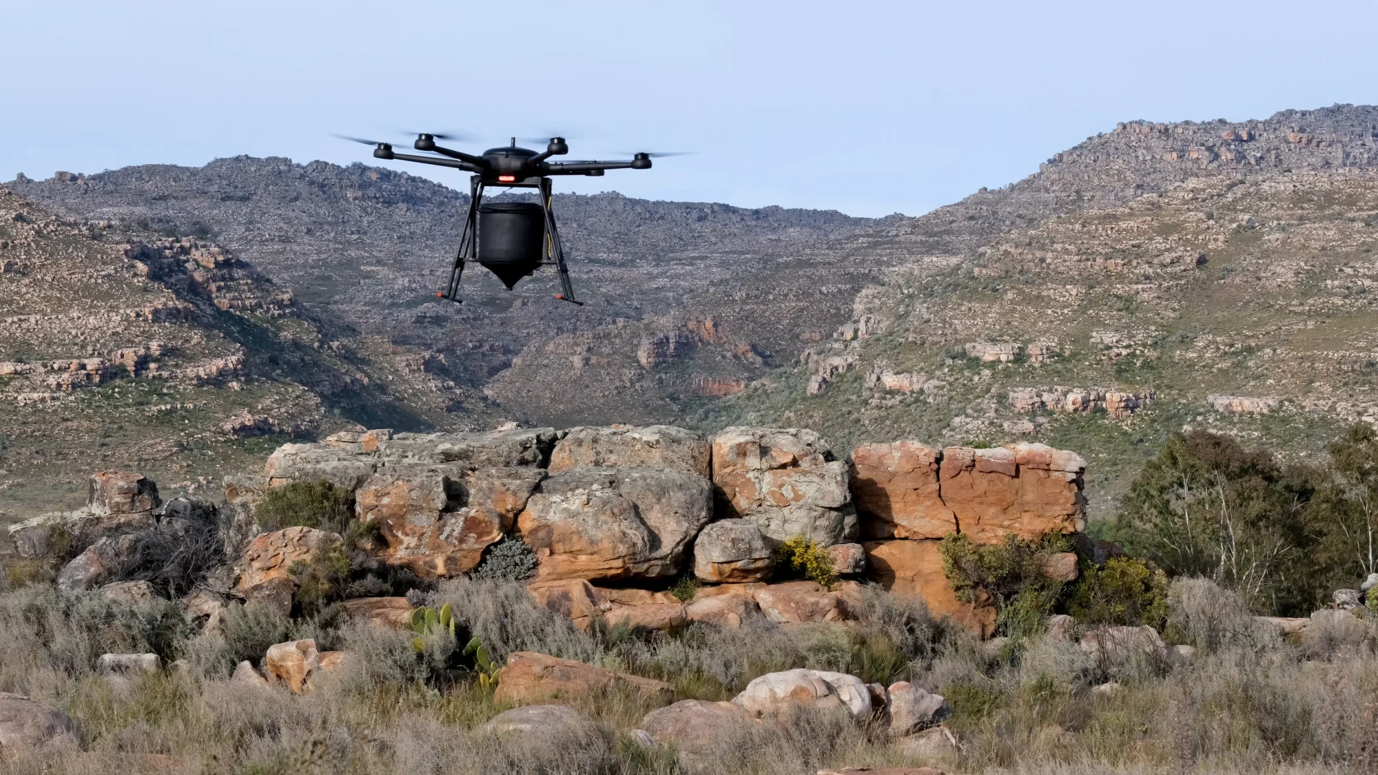 An AirSeed drone flying over rugged terrain. (AirSeed)