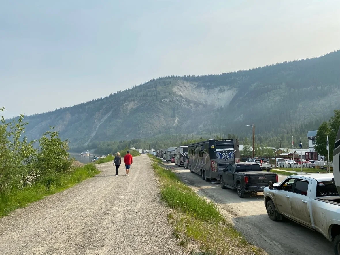 A long line of vehicles, including many RVs, waiting to cross over the Yukon river in Dawson City, Yukon. (Chris MacIntyre/CBC)