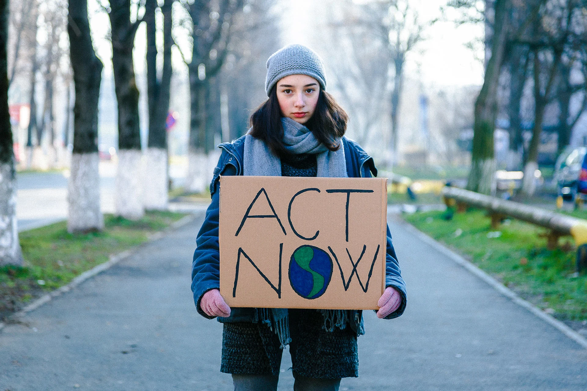 Portrait of a young teenage girl activist holding a sign protesting against climate change and global warming. (coldsnowstorm/ E+/ Getty Images)