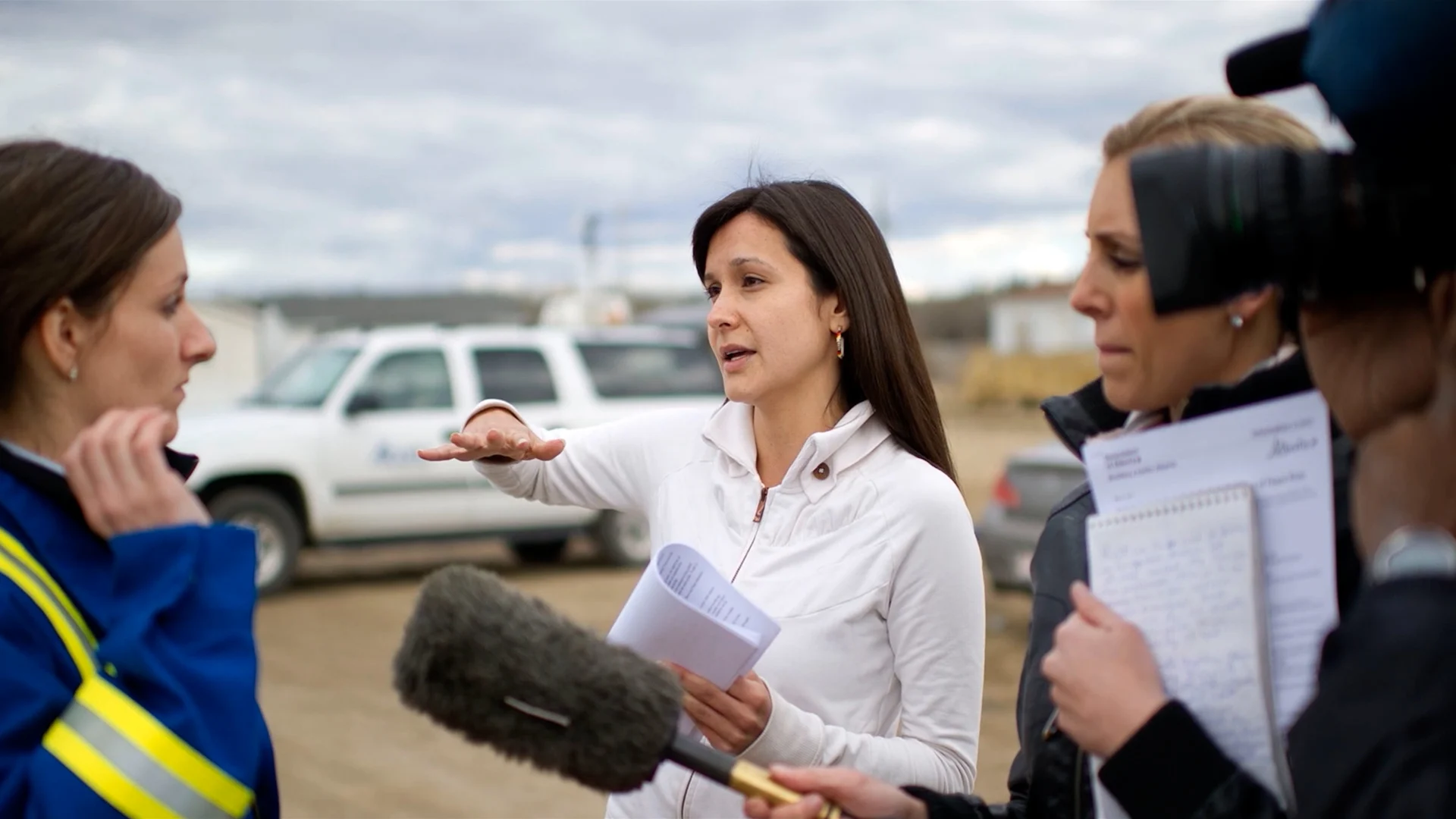Laboucan-Massimo (centre) speaking with reporters in Episode 1. (Power to the People)