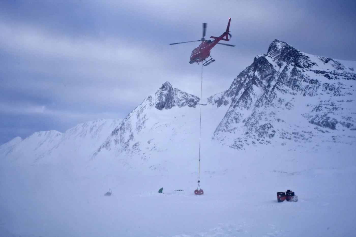 Fuel barrels were slung with a longline, shown here in March 2015, and deposited at strategic points so that the helicopter could reach polar bears in Southeast Greenland. The fieldwork required a four-hour daily helicopter commute from a Greenlandic coastal community or other bases to reach the bears’ habitat. (Fernando Ugarte/ Greenland Institute of Natural Resources)