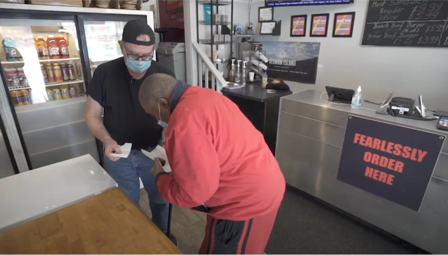 Brown offers a food sample to a customer (Provided)