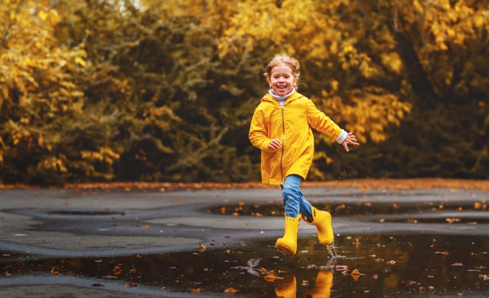 Getty Images: child running into a puddle on rainy day. Enjoying the rain
