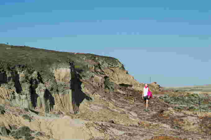 REUTERS: A handout photo shows Melanie During, a doctoral student in paleontology at the Uppsala University in Sweden, walking next to an embankment in southwestern North Dakota, U.S., August 2017, where fossils of fish including paddlefishes and sturgeons killed in the aftermath of the Yucatan asteroid impact 66 million years ago that caused one of Earth's worst mass extinctions of species. Courtesy of Jackson Leibach/Handout via REUTERS