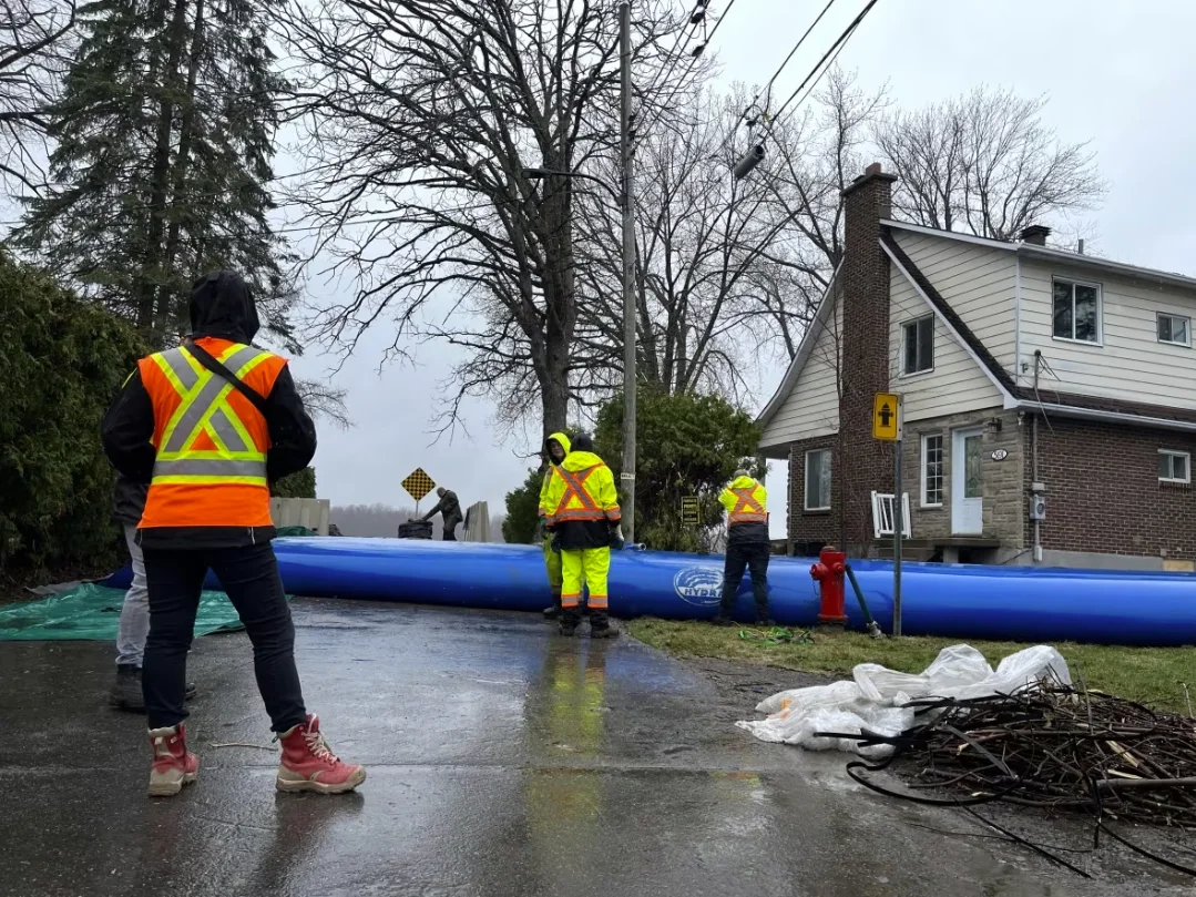 CBC: Workers install a temporary dike in Pierrefonds on Monday in preparation for a surge in spring water levels. (Hadi Hassin/Radio-Canada)