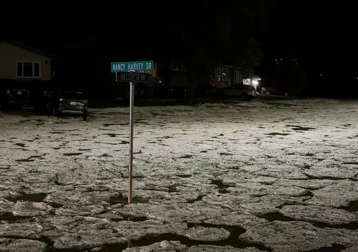 CBC: A residential street in Swift Current, Sask., is flooded after a hail storm overwhelmed drainage systems on July 6. (Shawn Mullin/CBC)