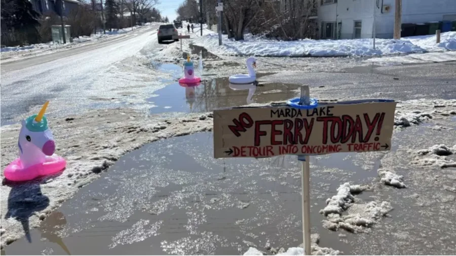 CBC: Jamie Ruff brought signs and floaties to an intersection near his home in Marda Loop Friday, bringing attention to a blocked storm drain. (Submitted by Jamie Ruff)