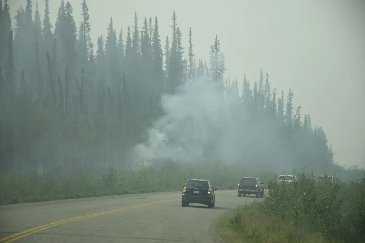 CBC: Cars driving through a wildfire in the Yukon (Jackie Hong/CBC)