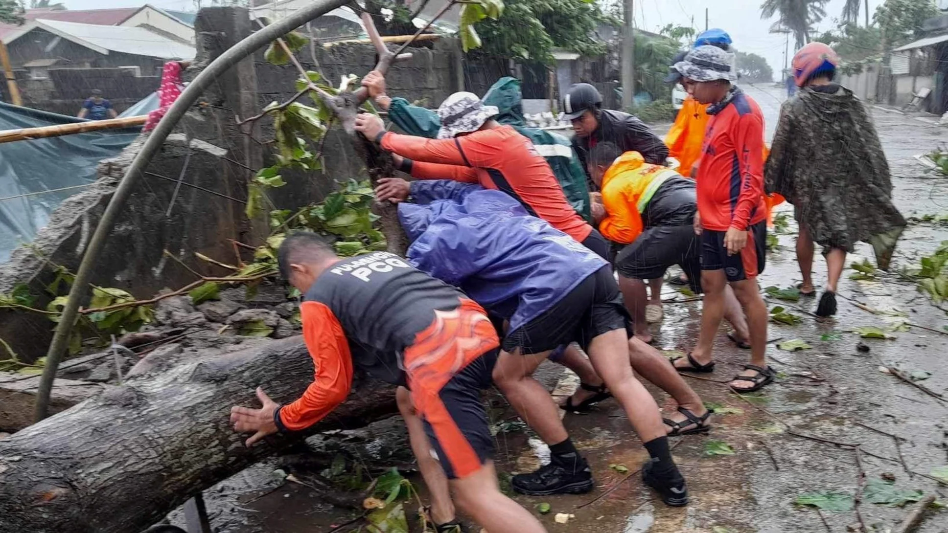 REUTERS: Members of the Philippine Coast Guard remove a fallen tree from a road following the onslaught of Typhoon Doksuri in Buguey, Cagayan province, Philippines, July 26, 2023. Philippine Coast Guard/Handout via REUTERS