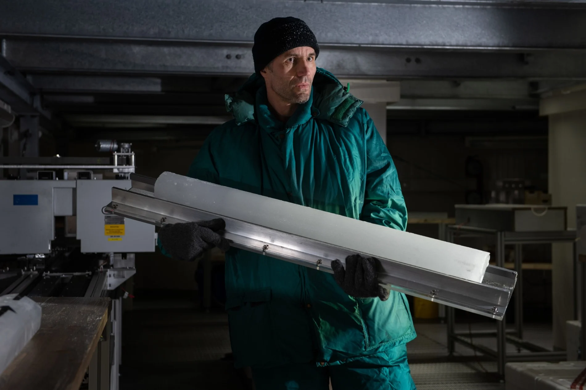 Glaciologist Johannes Freitag in the AWI ice laboratory with ice core at the saw stand. (Esther Horvath)