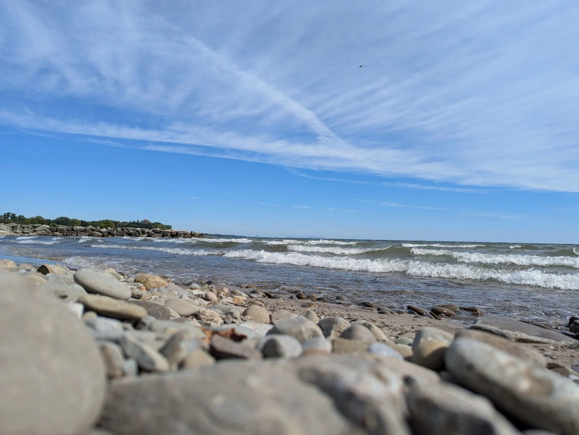 The Weather Network/Paul Campbell: Calm, sunny day, sun, blue sky, rocks, beach, waves: Oakville, Coronation Park at Lake Ontario. Sept. 27, 2024. 12:15pm.