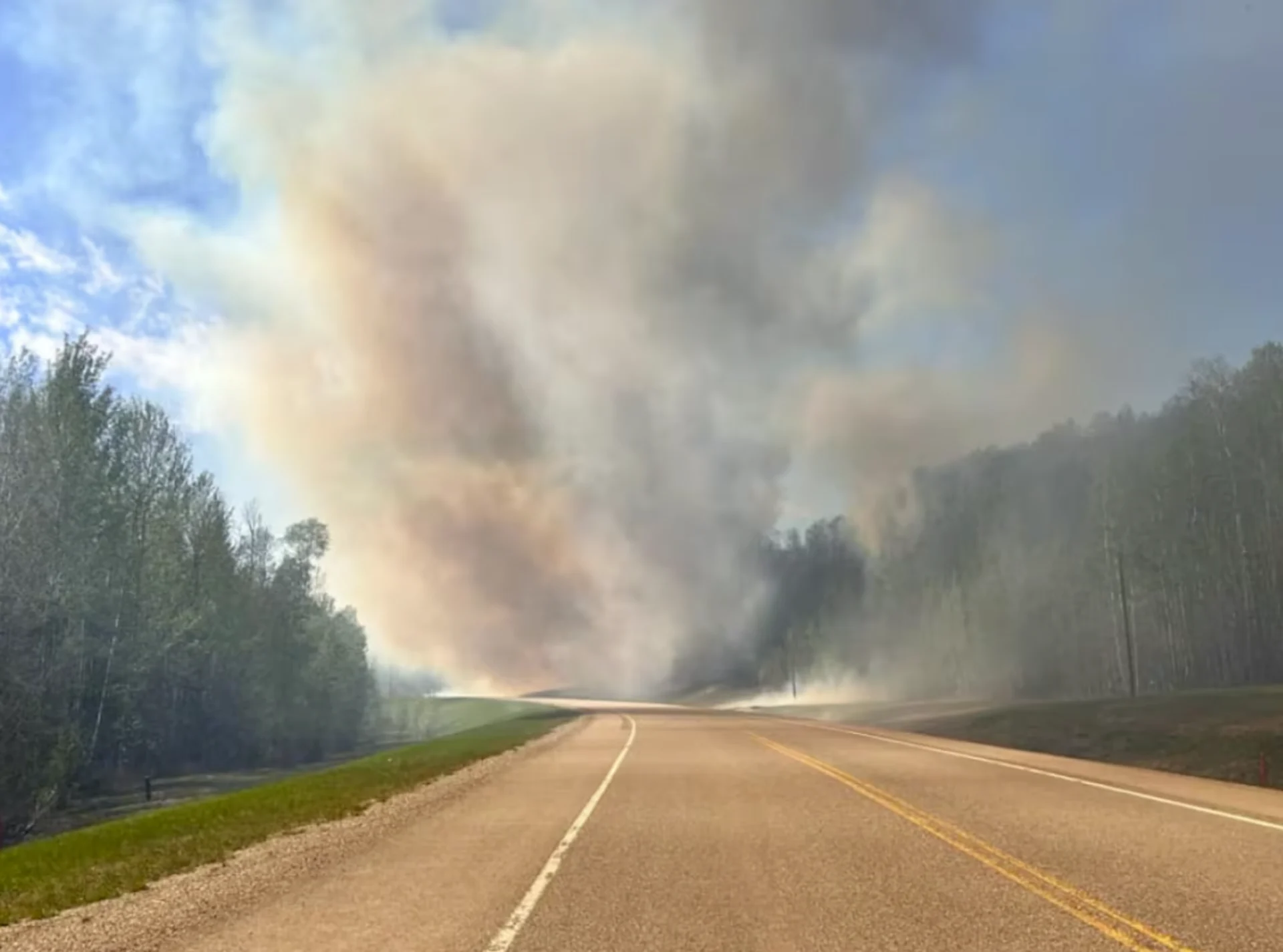 CBC: Heavy smoke is visible from an out of control wildfire that prompted instructions for several neighbourhoods in Fort Nelson to evacuate on Friday night. (Submitted by Angela Klondike)