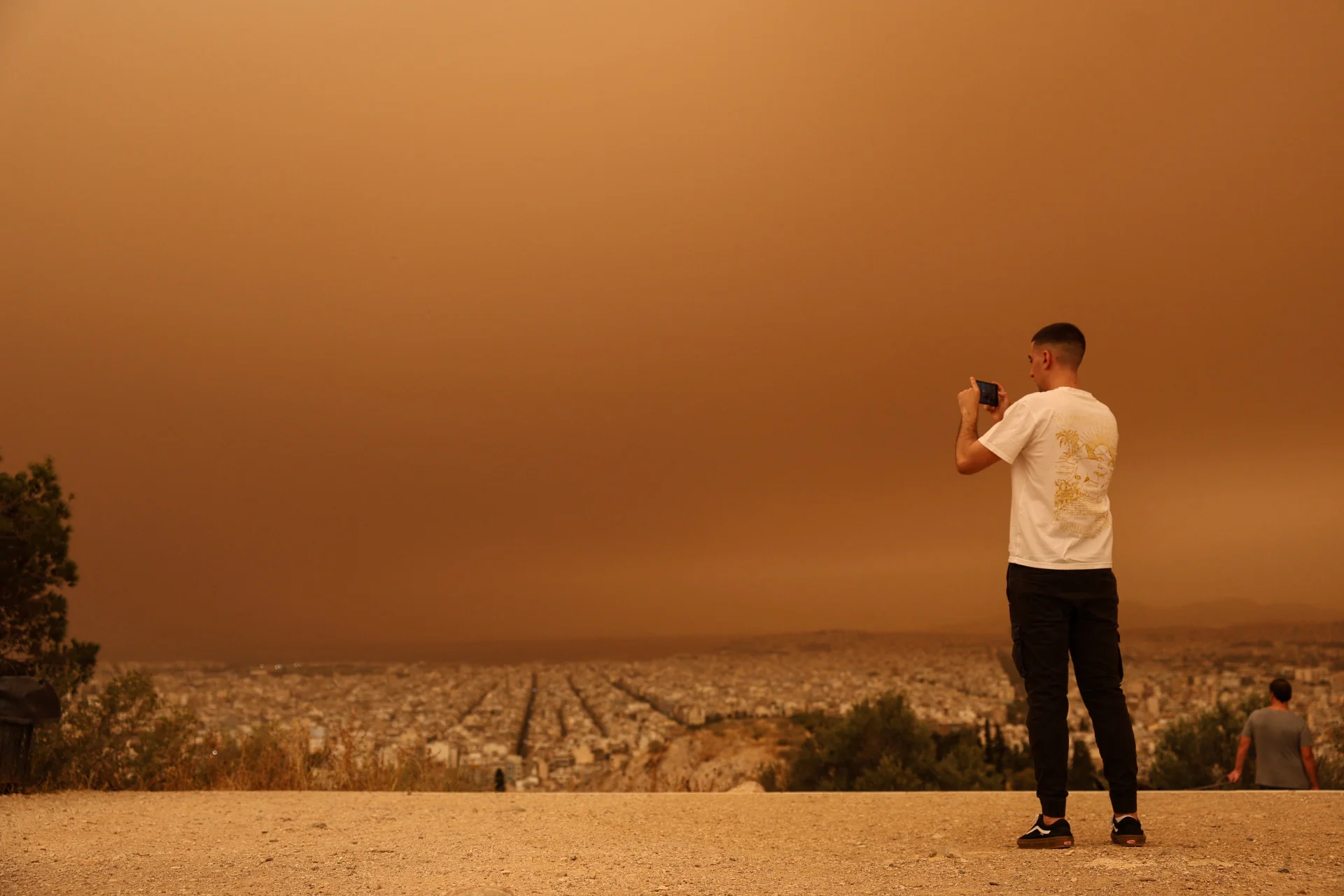 Reuters: A man takes pictures as African dust from the desert of Sahara covers the city of Athens, Greece, April 23, 2024. REUTERS/Louisa Gouliamaki