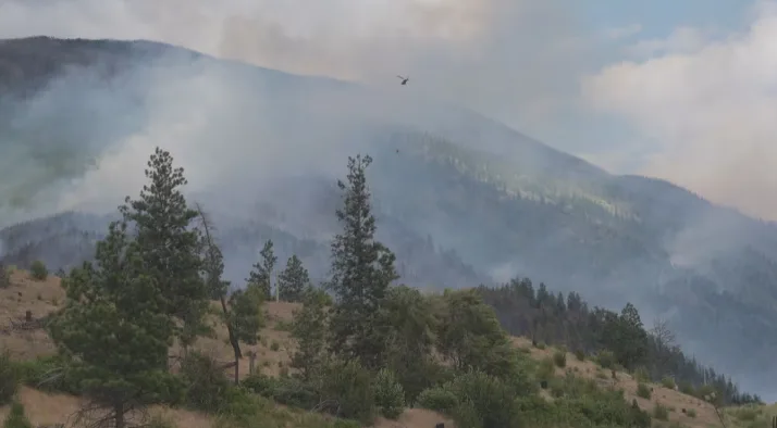 CBC: A helicopter buckets water on the Saw Creek wildfire south of Lytton on Saturday. (Alanna Kelly/CBC)