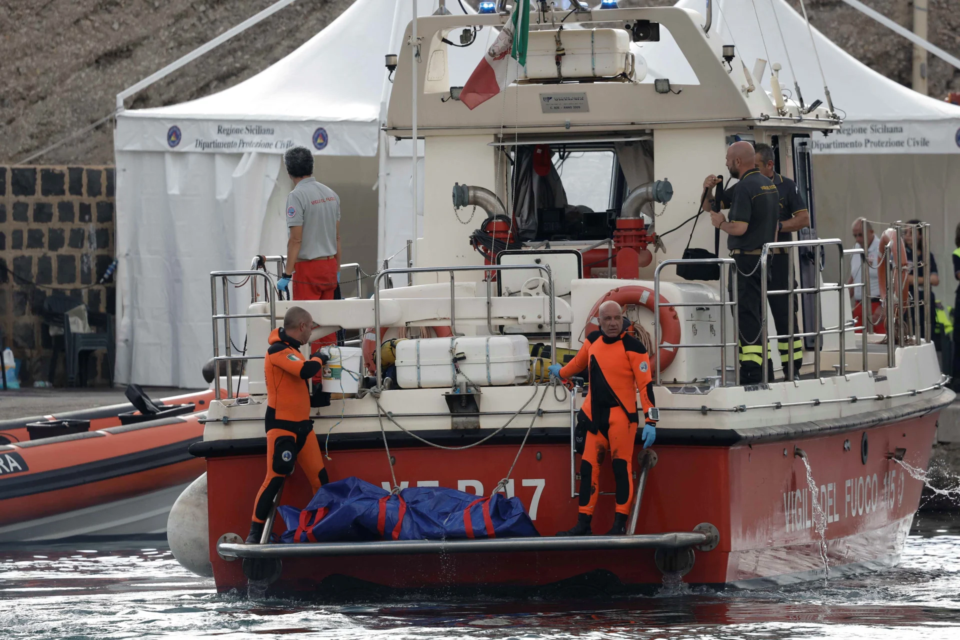 REUTERS: Rescue personnel work near a bodybag at the scene where a luxury yacht sank, off the coast of Porticello, near the Sicilian city of Palermo, Italy, August 22, 2024. REUTERS/Louiza Vradi