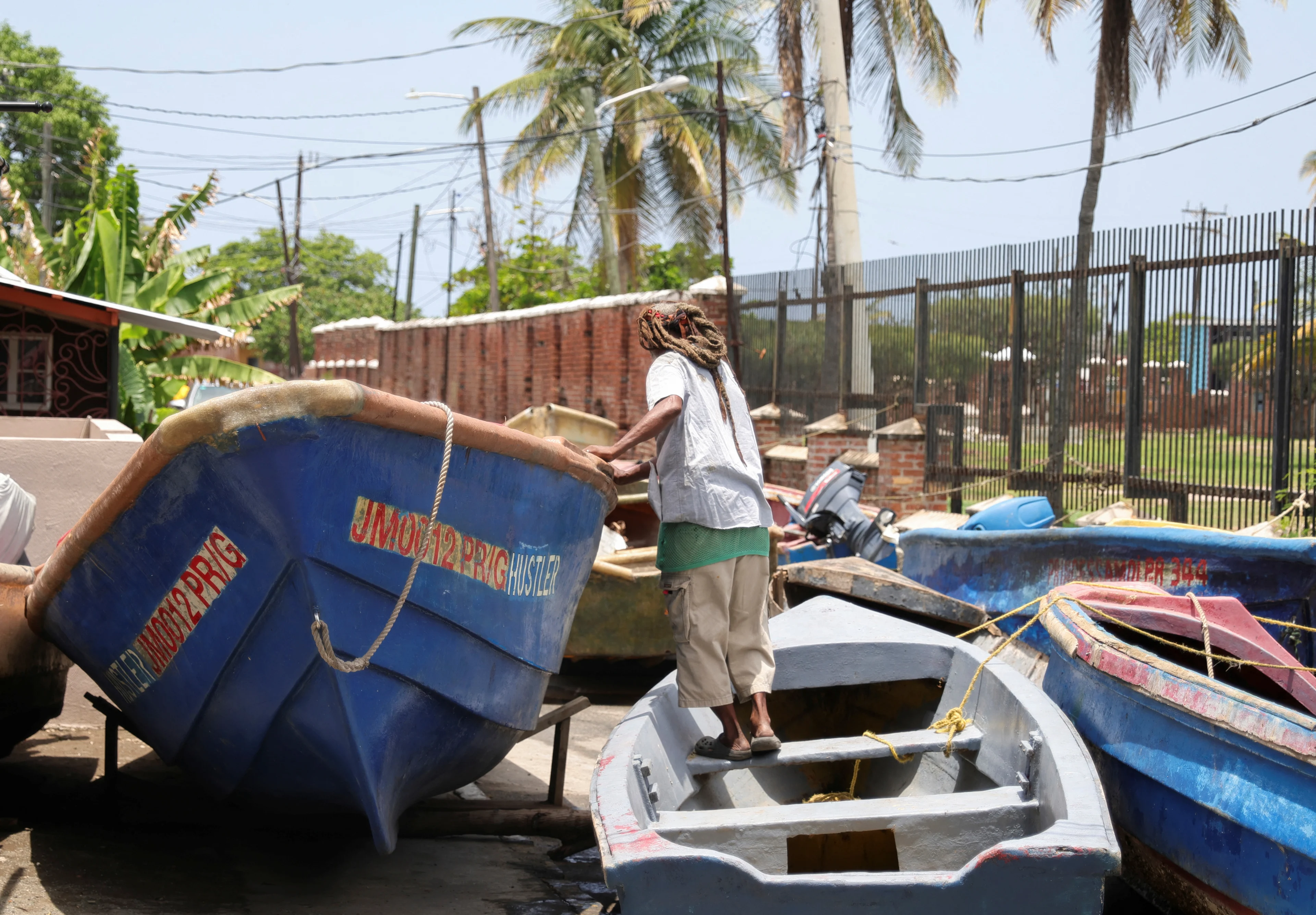 REUTERS: A fisherman checks a boat that was pulled from the water ahead of the arrival of Hurricane Beryl, in Port Royal, Jamaica July 2, 2024. REUTERS/Gilbert Bellamy