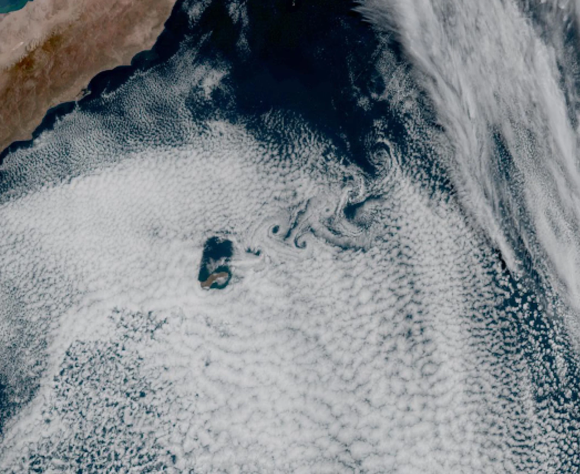 Island churns out dozens of mesmerizing, swirling clouds