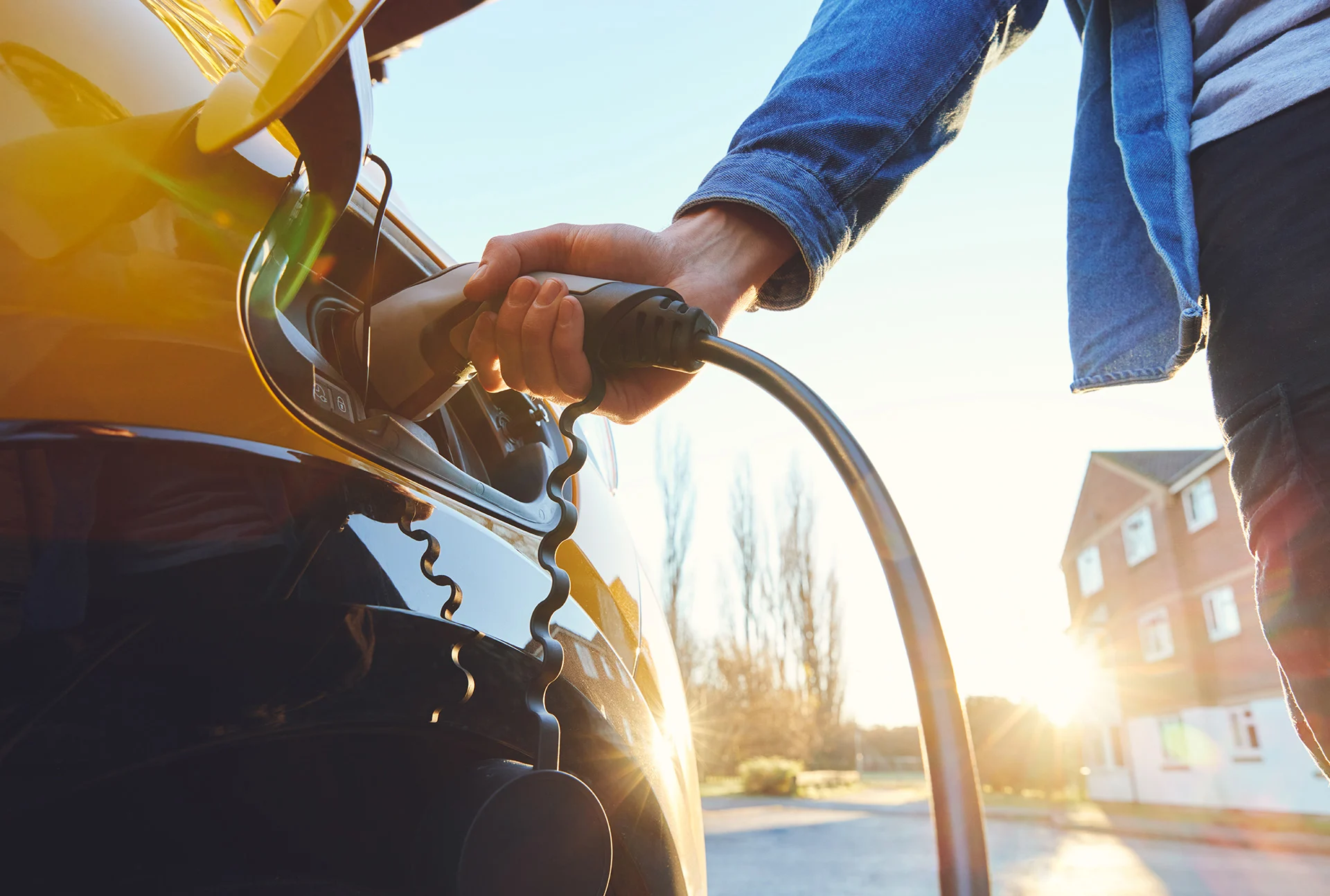  Person plugging in an electric car to be charged. (SouthWorks/ iStock/ Getty Images)