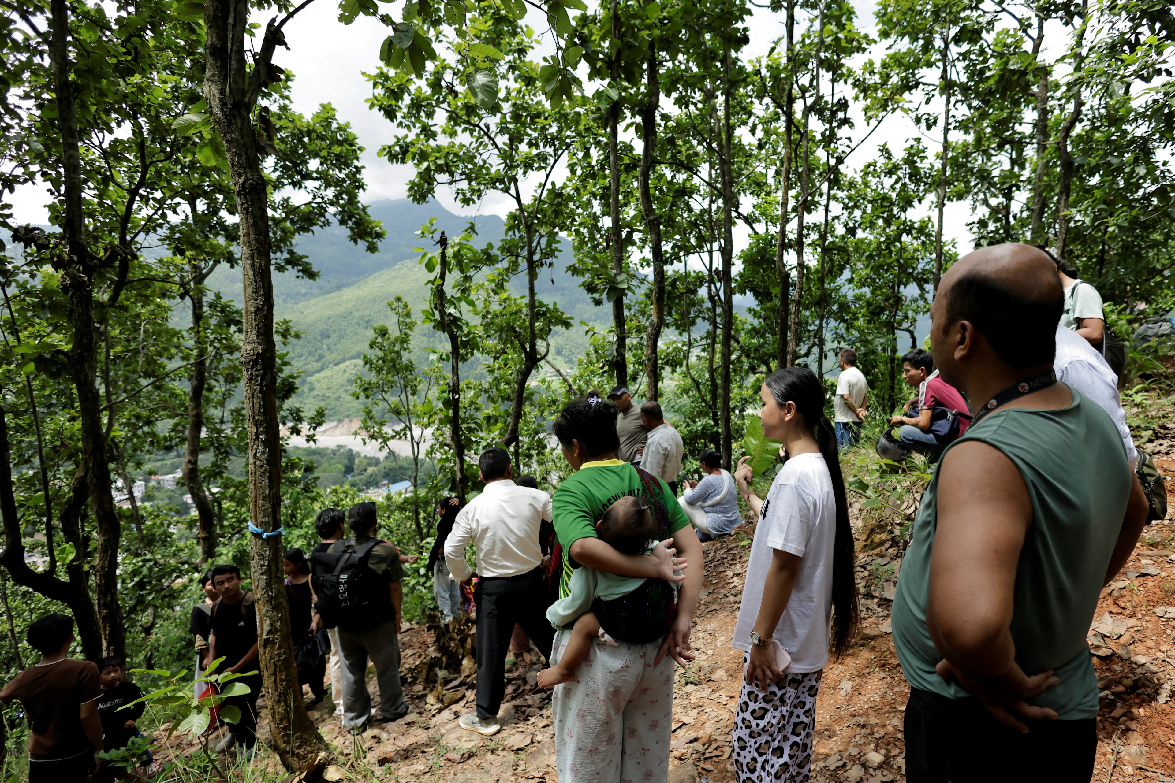 REUTERS: People stand on a hill after reaching high ground following a warning that a lake has broken its banks, two days after flash floods and a mudslide in Trishuli, Nuwakot district, Nepal, August 28, 2026. REUTERS/Navesh Chitrakar