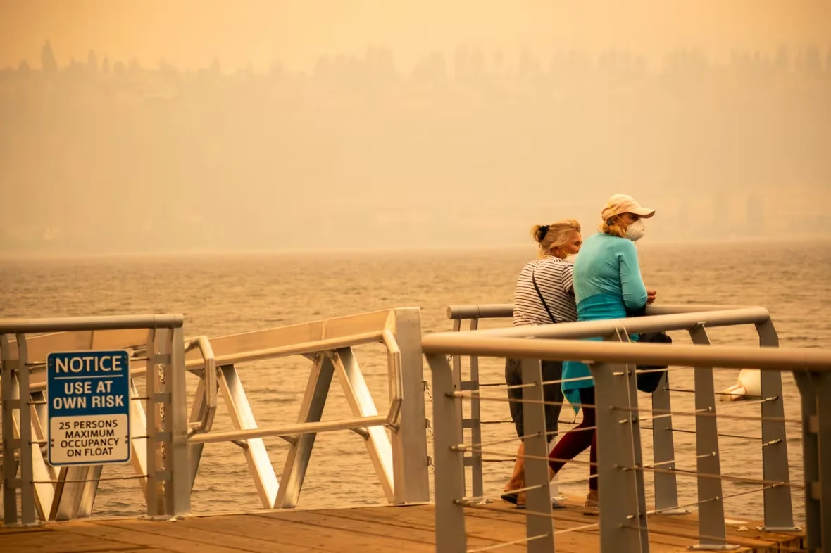 two-senior-women-in-the-pandosy-waterfront-park-in-kelowna-b-c-wear-masks-amid-smoke-from-mcdougall-creek-wildfire-in-west-kelowna-on-aug-18-2023/Winston Szeto/CBC