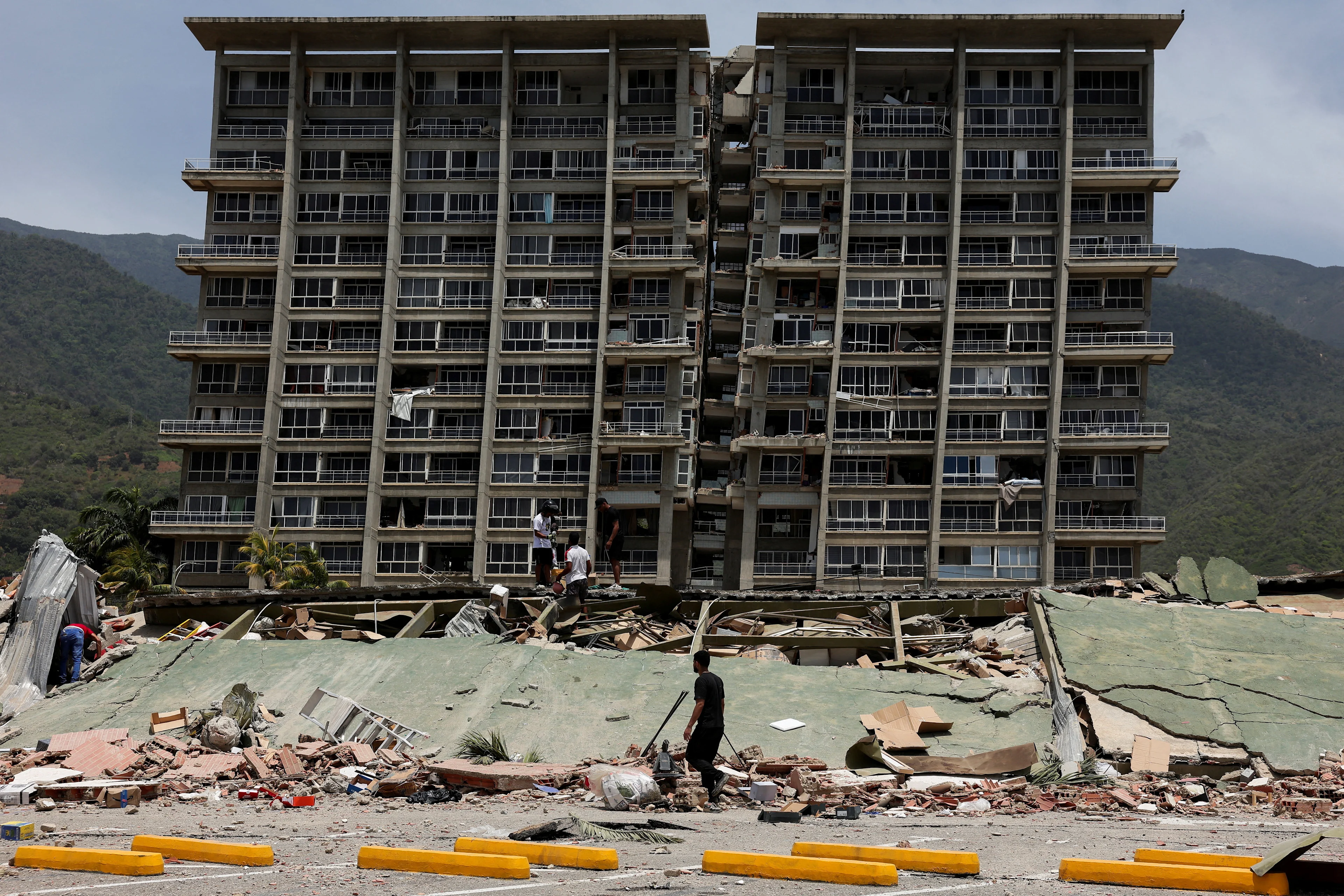 REUTERS: People inspect the rubble of a collapsed building after earthquakes hit the country, in La Guaira, Venezuela, June 25, 2026. REUTERS/Gaby Oraa