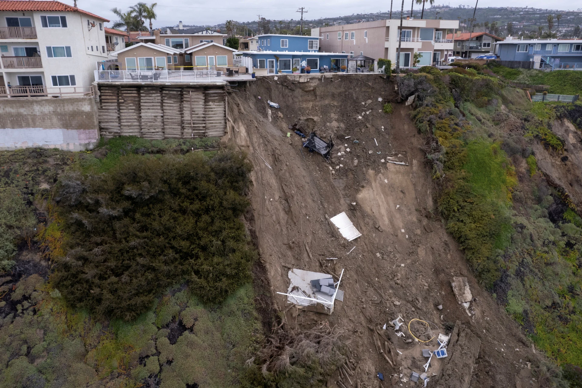 Reuters: FILE PHOTO: A backyard pool is left hanging on a cliffside after torrential rain brought havoc on the beachfront town of San Clemente, California, U.S. March 16, 2023. REUTERS/Mike Blake/File Photo