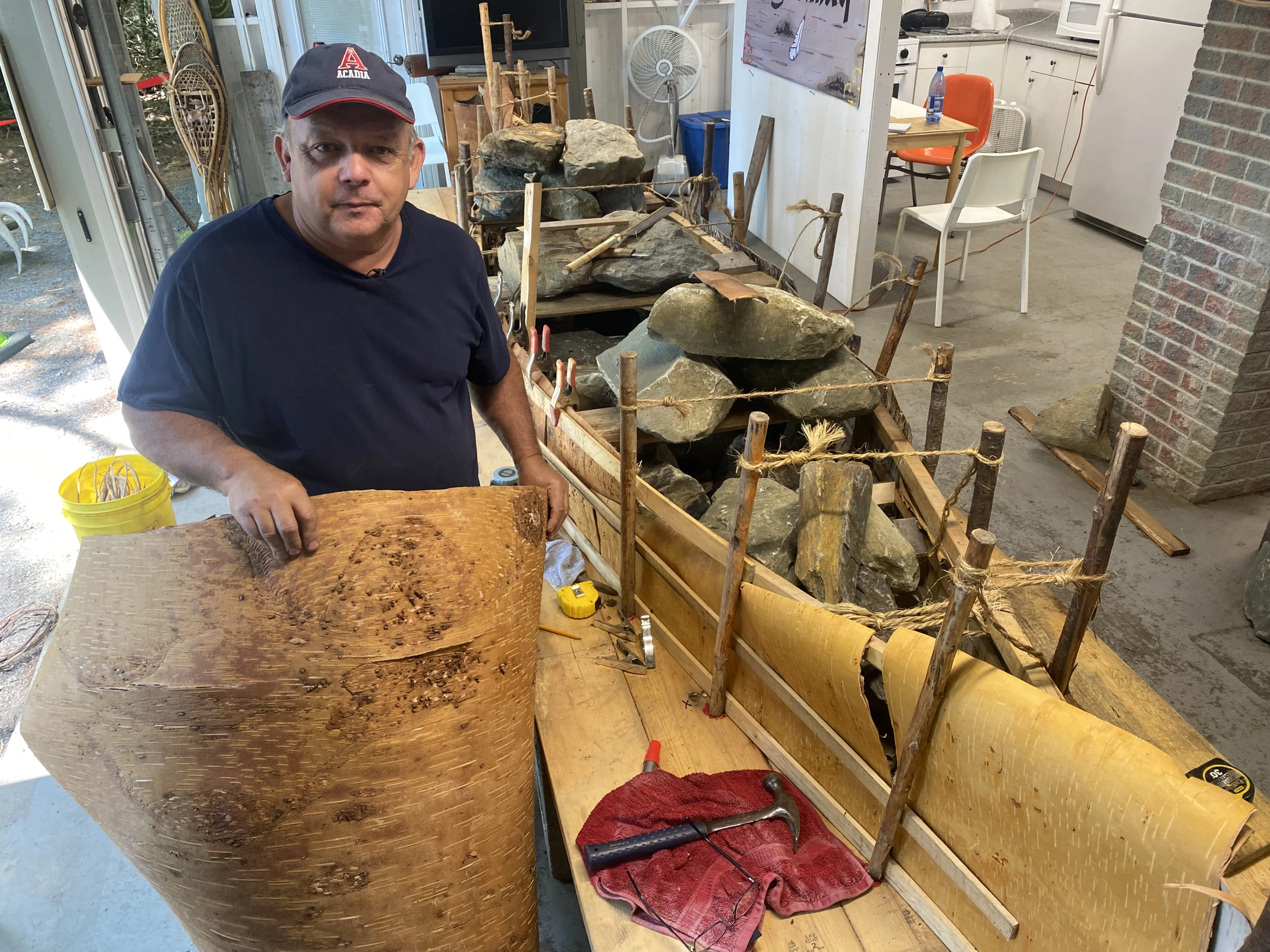 Nathan Coleman: Showing Todd Labrador at his canoe building workshop at Kejimkujik National Park and Historic site along with a closeup of the birch bark with lumps on it. 2