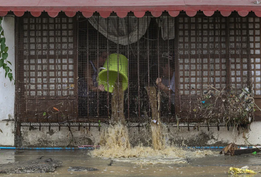 Reuters/Source: Earvin John Perias/ZUMA Press Wire/dpa: Residents remove flood water inside their house a day after Tropical Storm Nalgae brought heavy rains and strong winds to the Philippines.