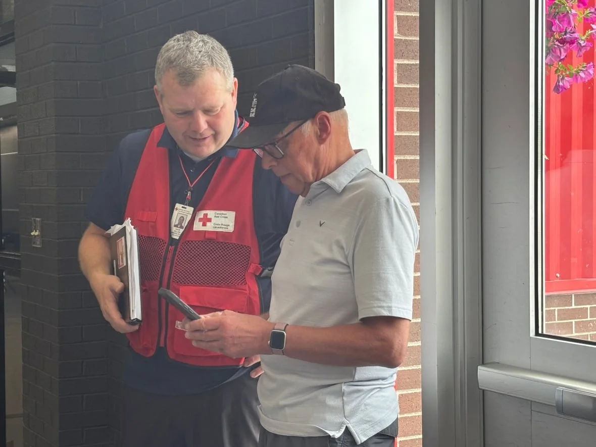 CBC Dave Dillon of the Canadian Red Cross confers with Minister of Justice and Public Safety John Haggie in Gander. (David Newell/CBC)